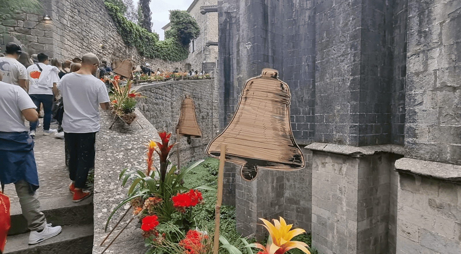 Floral installation in a stone moat beside a historic building during Temps de Flors in Girona