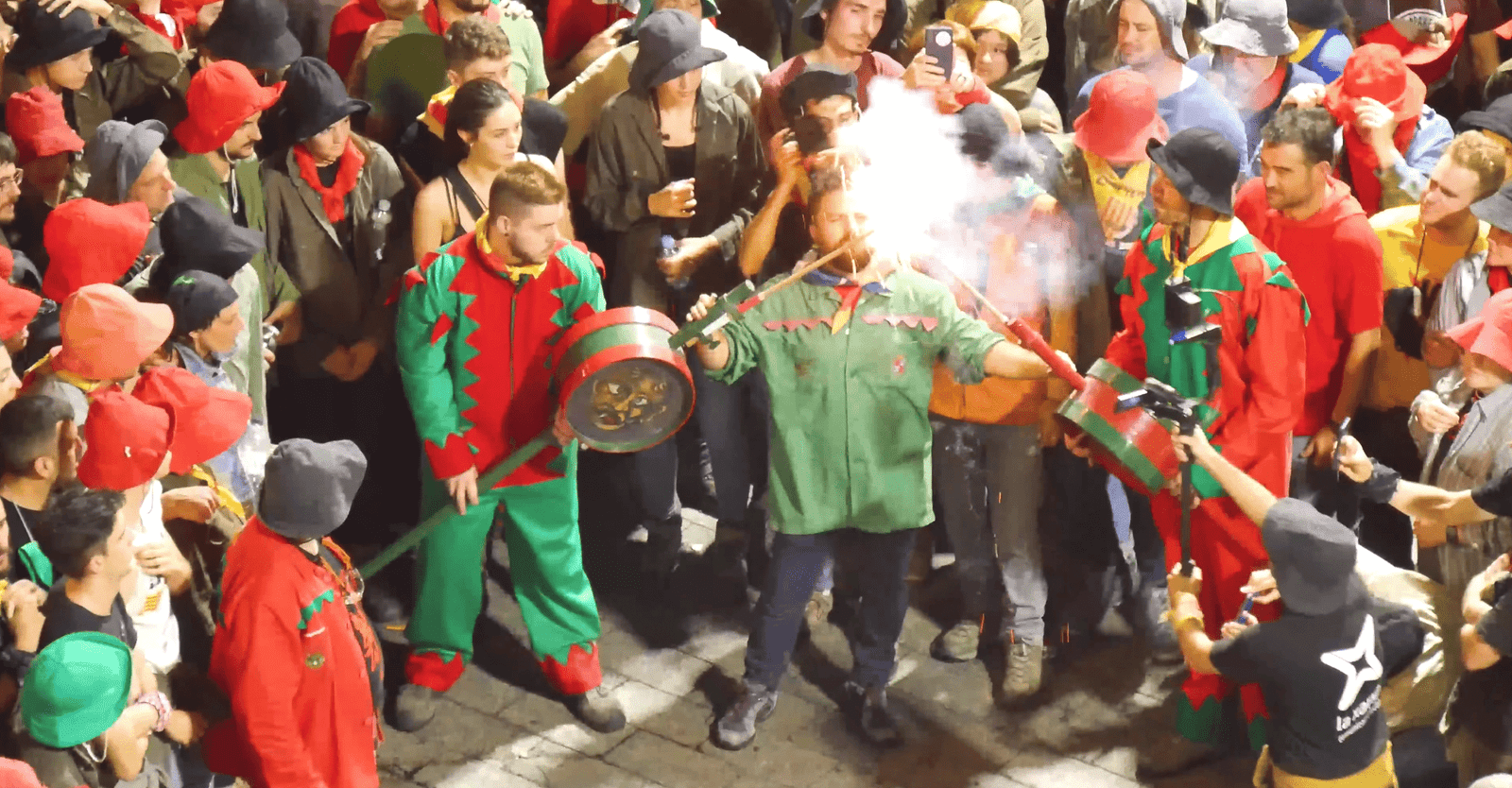 Fire devil holding a spark-emitting artifact during La Patum