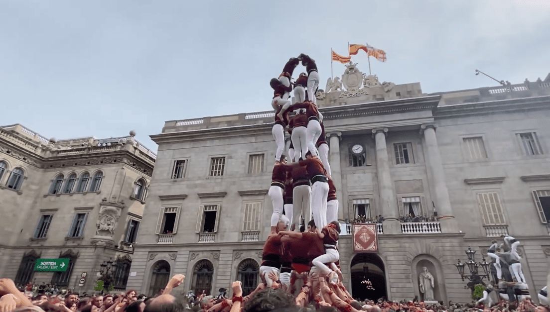 A casteller human tower rising in front of Barcelona’s City Hall during La Mercè in Plaça Sant Jaume.