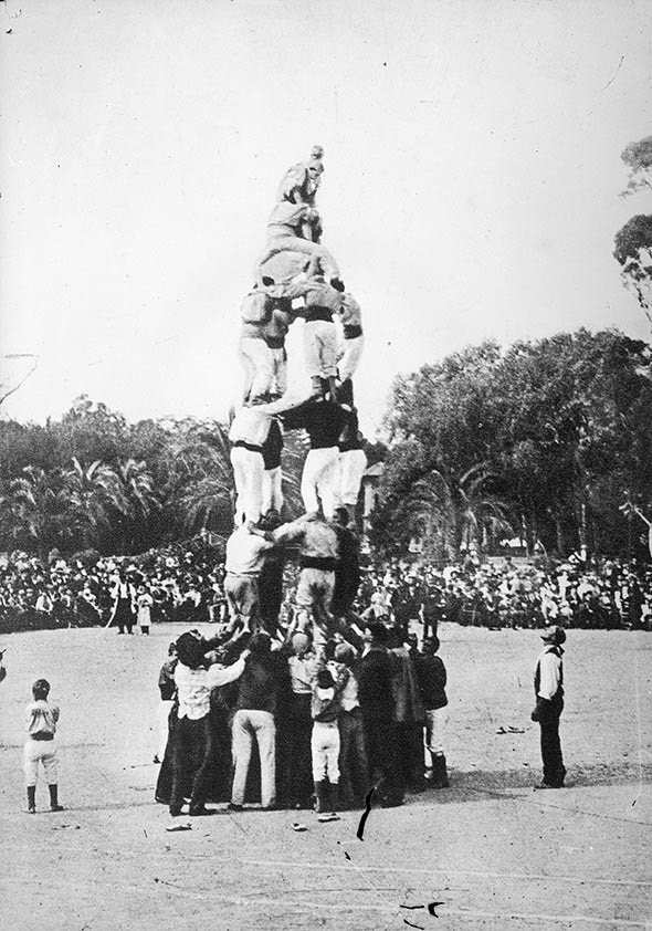 Vintage image of castellers building a human tower during La Mercè festival in 1902.