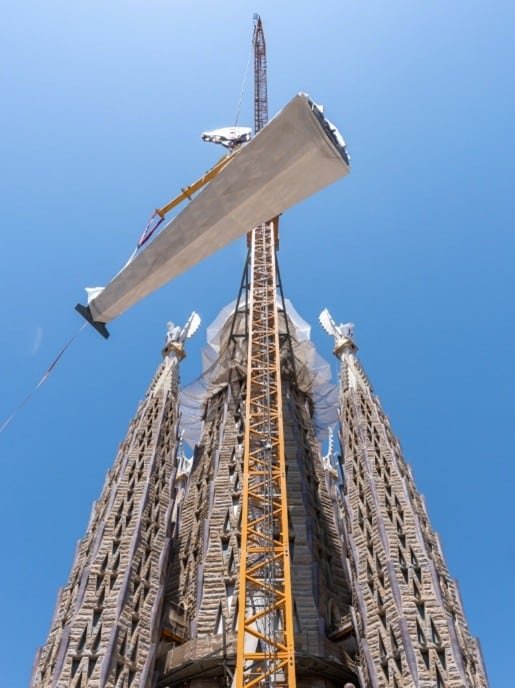 Crane lifting the lower arm of the cross for installation on the Tower of Jesus Christ at the Sagrada Familia