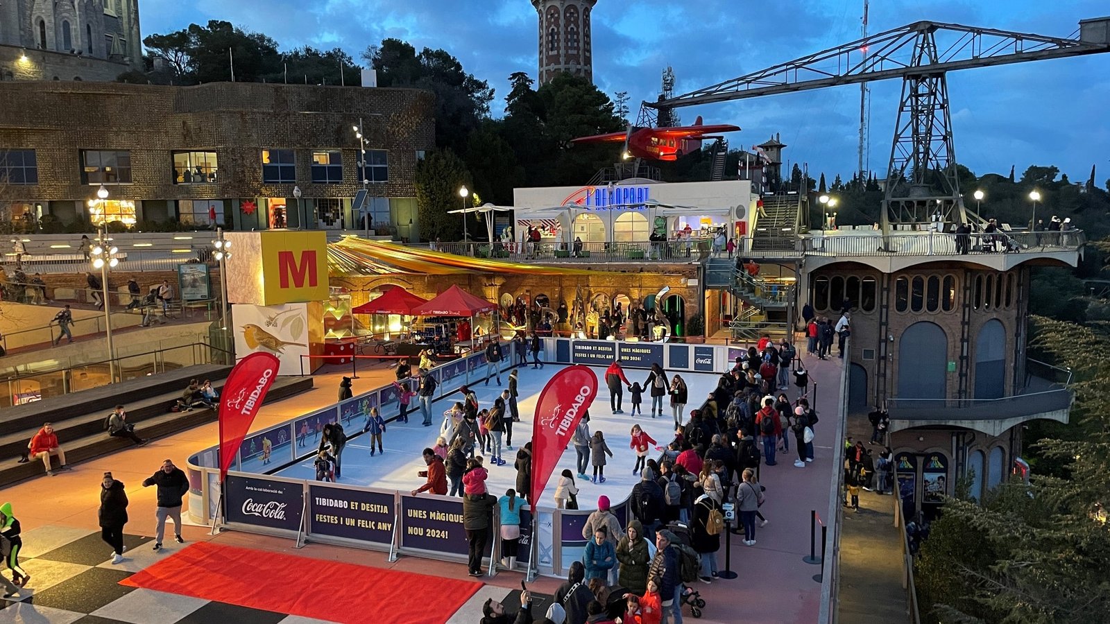 Families ice skating at Tibidabo’s illuminated rink during the winter season in Barcelona.