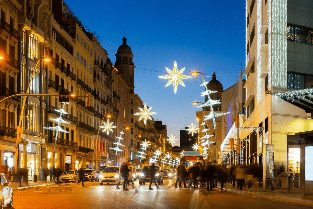 Barcelona street decorated with white star-shaped Christmas lights at dusk, with pedestrians crossing.