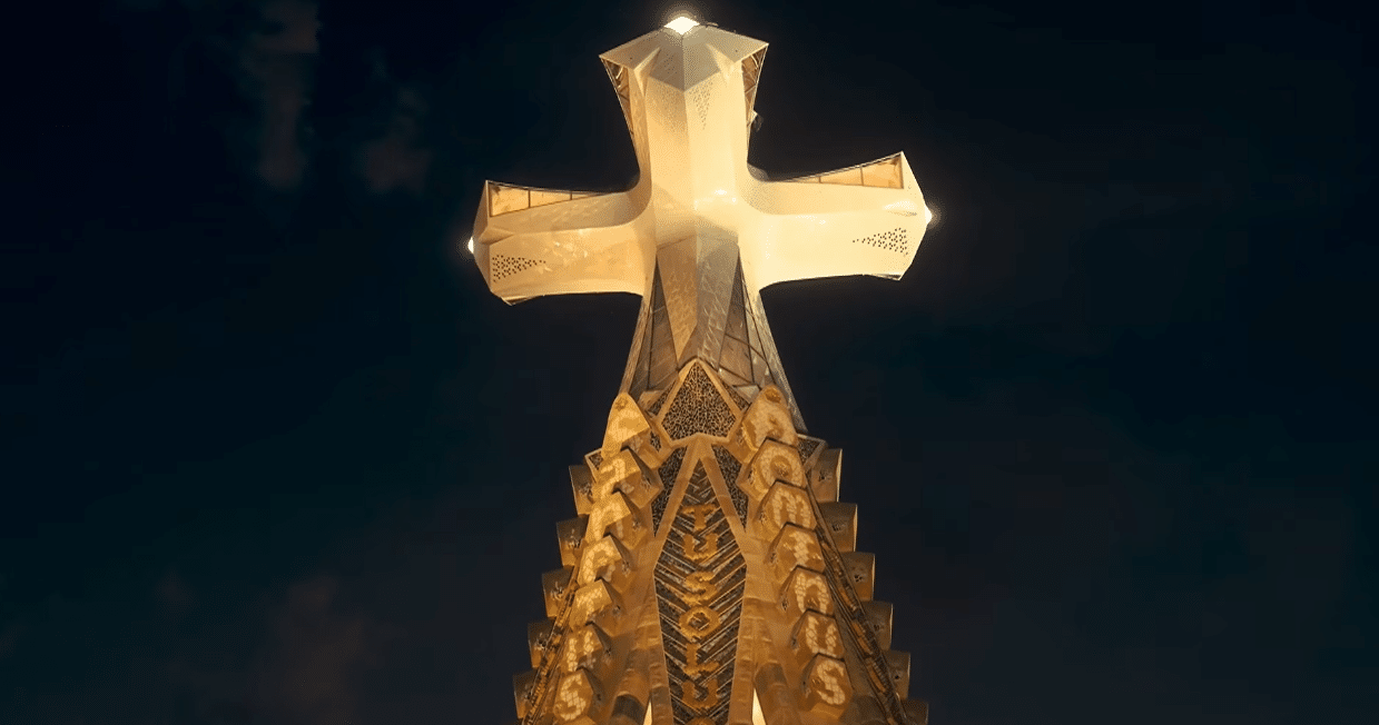 The illuminated cross atop the Tower of Jesus shining above Barcelona during the Gaudí centenary celebration.