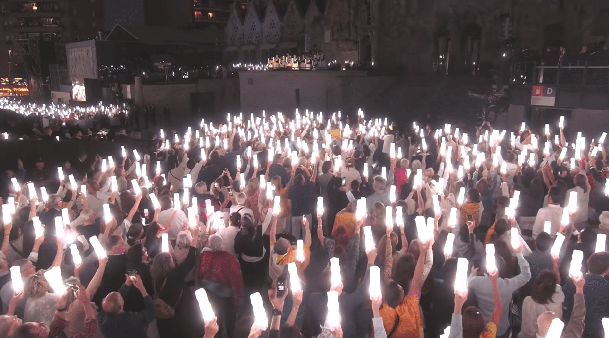 Thousands of people holding lights during the Antoni Gaudí centenary celebration at the Sagrada Familia.