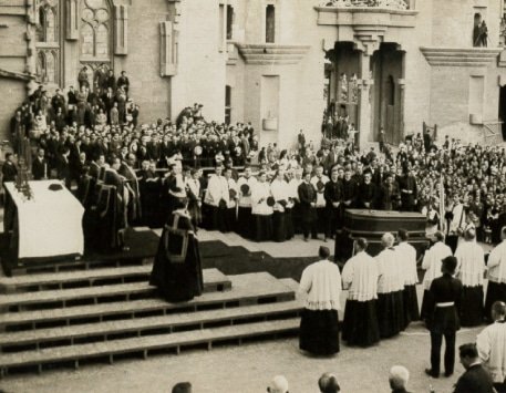 Historic funeral ceremony of Antoni Gaudí in Barcelona in June 1926 surrounded by mourners and clergy.