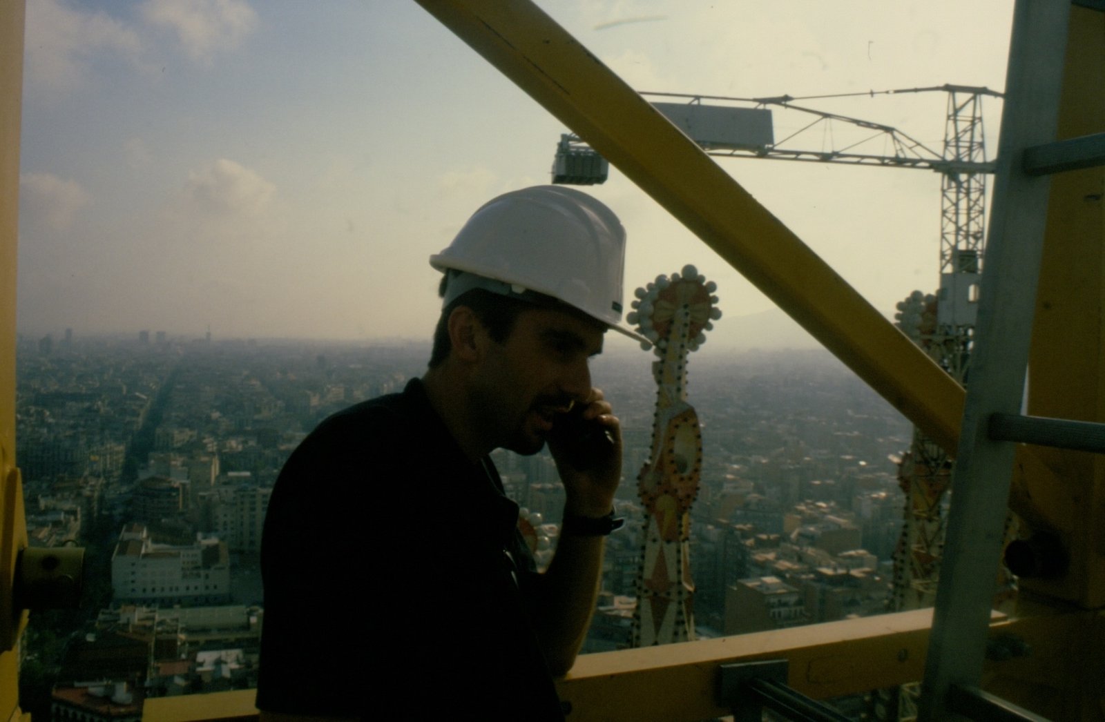 At the Heart of Gaudí’s Legacy: Javier in 1999 Javier seated on Sagrada Familia’s construction site in 1999, wearing a white helmet