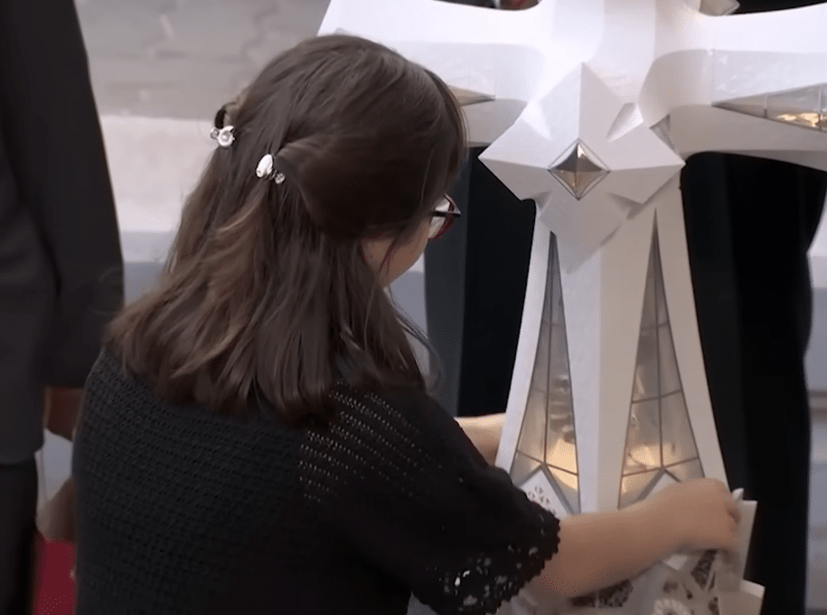 Juliana exploring and explaining a tactile model of the Sagrada Familia during the Gaudí centenary celebration.
