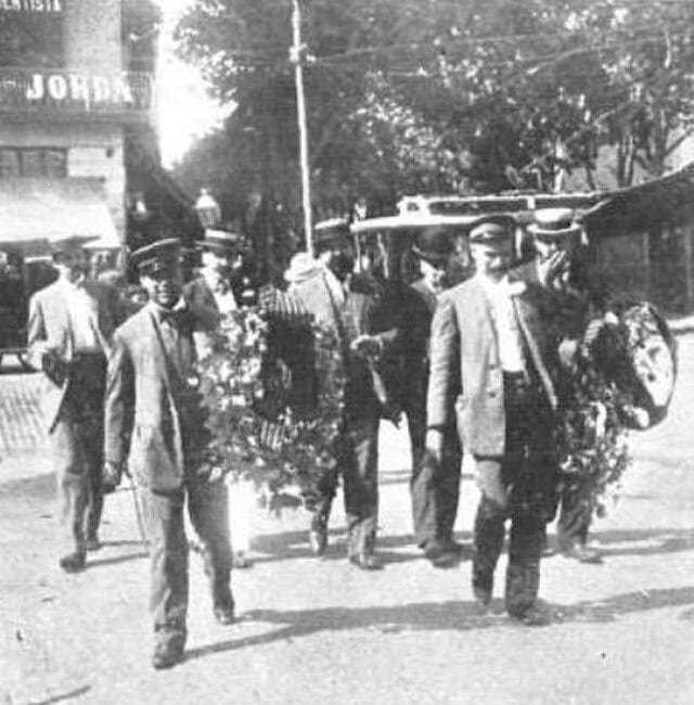 1907 black-and-white procession carrying wreaths and flowers to the Rafael Casanova monument in Barcelona during an early La Diada commemoration.