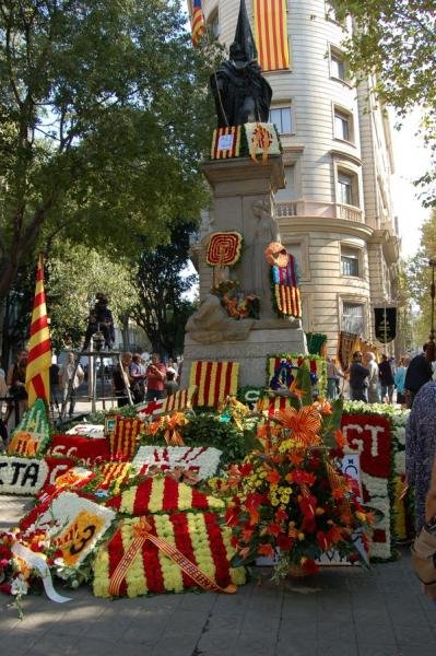 Floral offerings at the Rafael Casanova monument during La Diada in Barcelona.