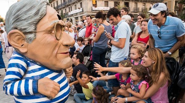 Capgròs giant head character surrounded by families during La Mercè in Barcelona