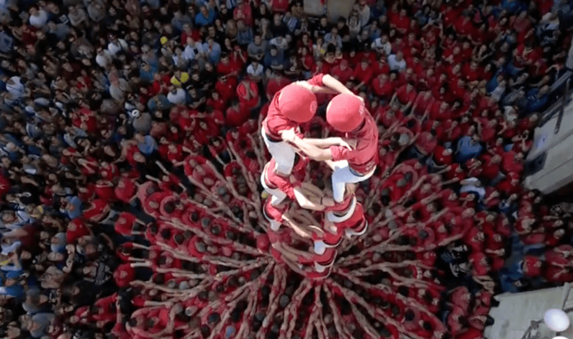 Aerial view of a Castellers human tower surrounded by a crowd at La Mercè