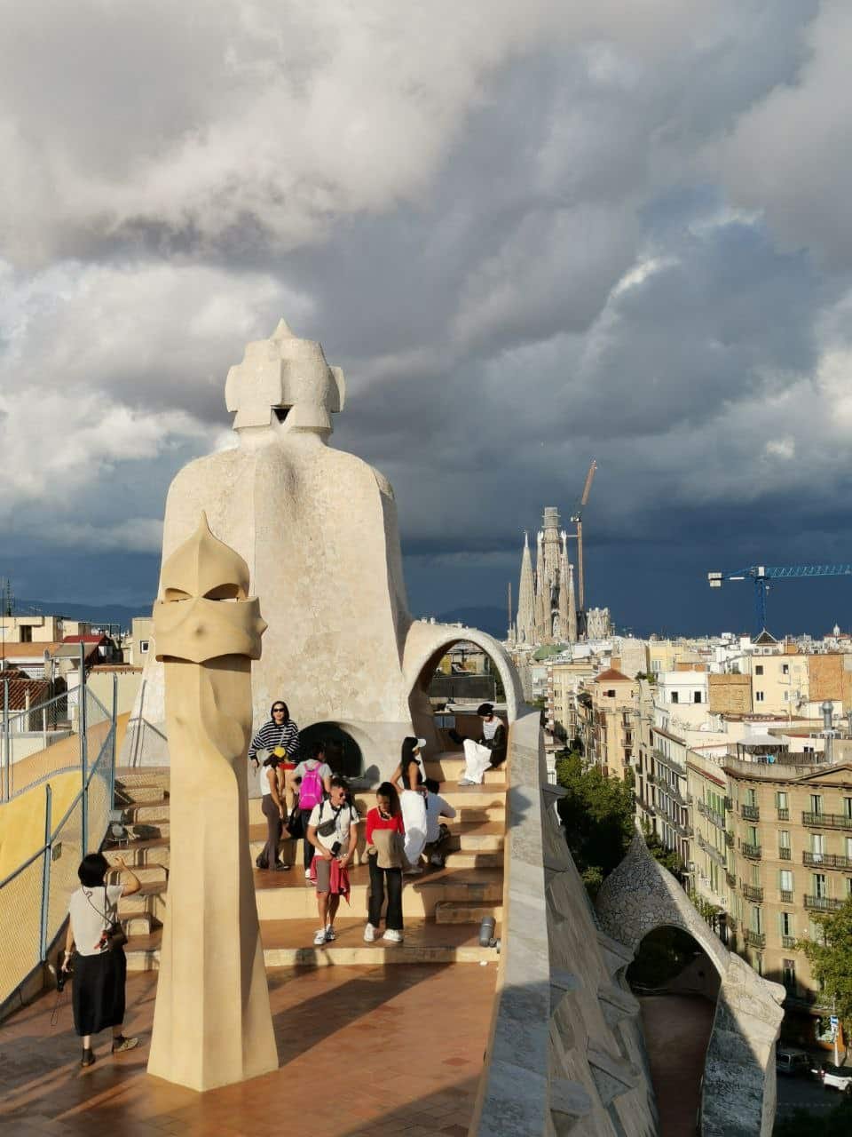 Visitors on the rooftop of Casa Batlló enjoying panoramic views of the Sagrada Família in Barcelona.